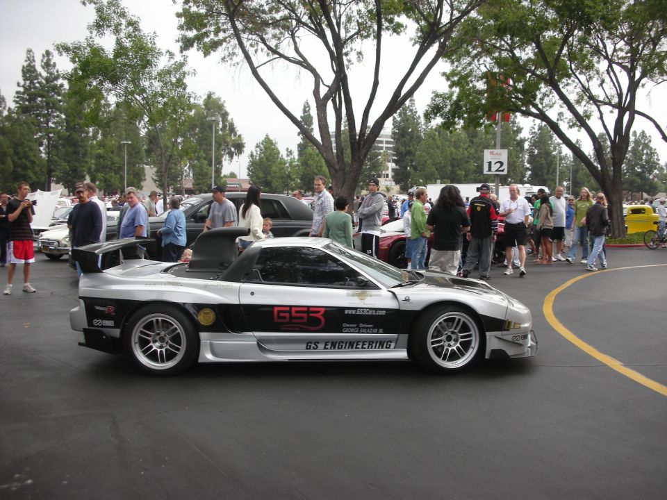 Silver sports car with black racing stripes and 'GS3 ENGINEERING' text, parked at an outdoor event