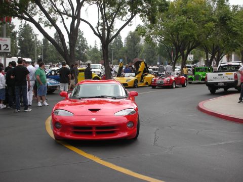 1998 Ford Crown Victoria - Red Dodge Viper at a car meet with multiple vehicles and spectators present.