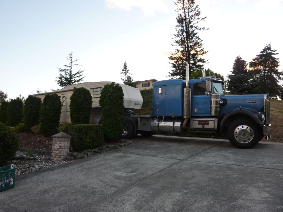 Blue 1981 Kenworth W900A semi-truck, side view, towing a white trailer