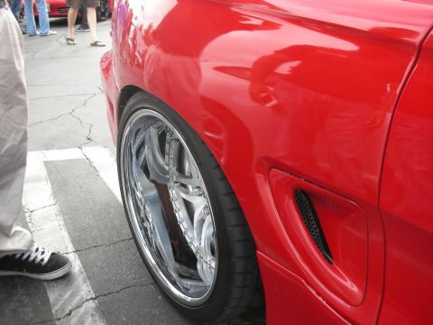 1998 Ford Crown Victoria - Detail shot of a custom wheel on a red vehicle's fender.