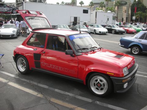 1998 Ford Crown Victoria - A red Renault 5 Turbo 2 is parked in a lot, with its rear hatch open, alongside other vehicles.