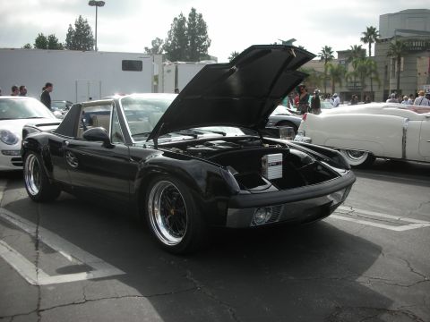 1998 Ford Crown Victoria - A black Porsche 914 is parked with its hood open, revealing its engine compartment and a stereo system.