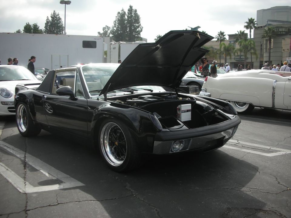 Black Porsche 914 with hood open, showing engine bay and aftermarket stereo