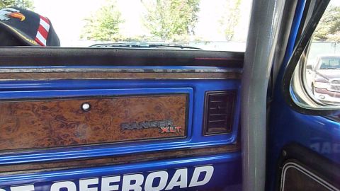 1981 Kenworth W900A - Interior view of a blue dashboard wood grain trim and a "RANGER XLT" badge.