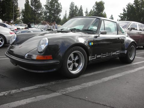 1998 Ford Crown Victoria - A black Porsche 911 Targa is parked in a lot next to other vehicles.