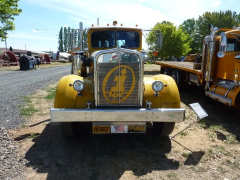 1981 Kenworth W900A - A yellow truck is parked outside, with another truck visible to its right.