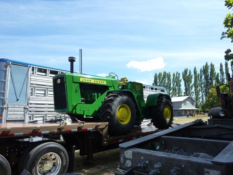Green John Deere tractor on a flatbed trailer
