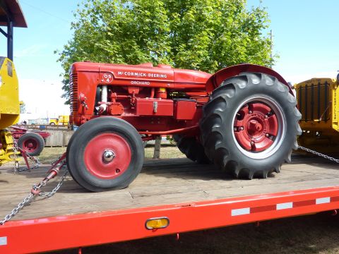 1981 Kenworth W900A - A red McCormick-Deering Orchard tractor is parked on a flatbed trailer.