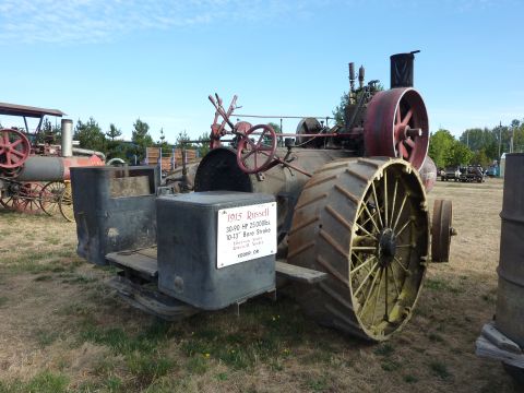 1981 Kenworth W900A - A vintage 1915 Russell steam tractor is displayed outdoors next to another older vehicle.