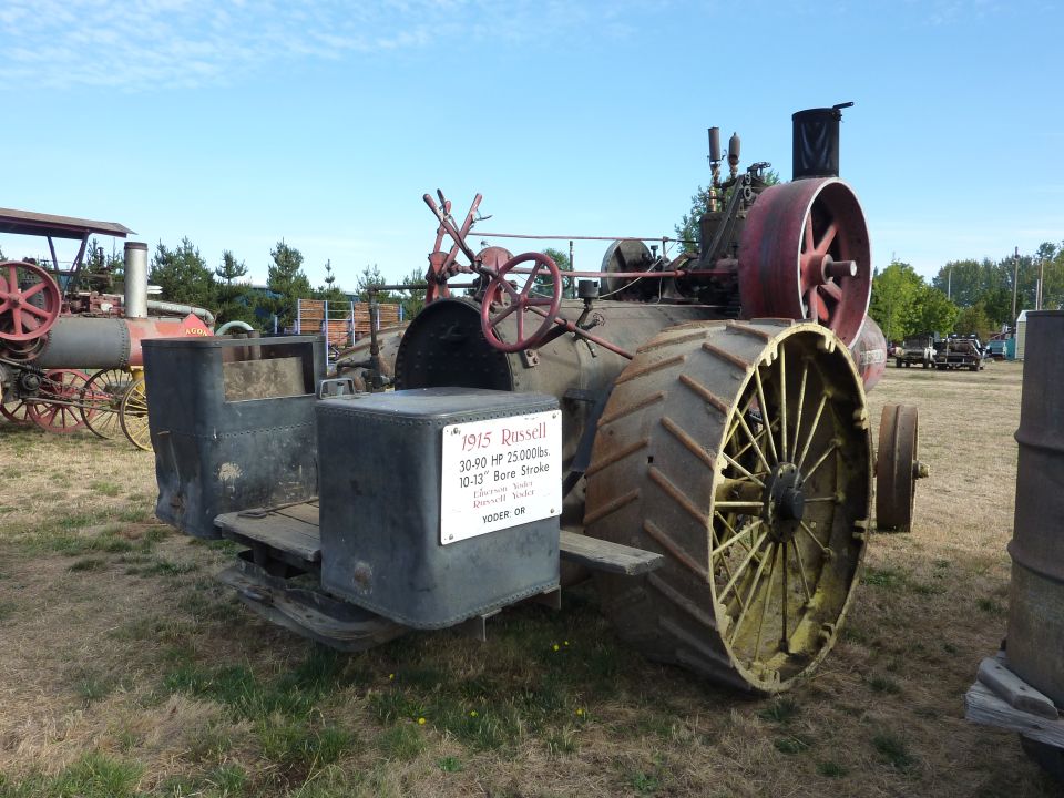 1915 Russell steam tractor with large spoked rear wheels and a metal box on the side