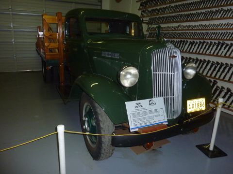 1981 Kenworth W900A - A 1936 Dodge truck is displayed indoors, with a collection of tools mounted on the wall behind it.