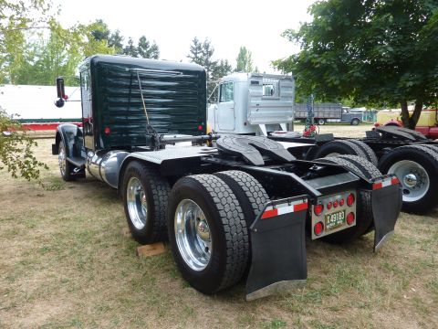 1981 Kenworth W900A - Rear view of a dark green 1981 Kenworth W900A semi-truck, with another truck visible behind it.