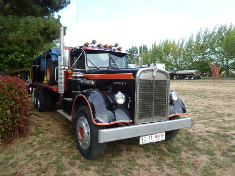 1981 Kenworth W900A - A vintage Kenworth truck with a flatbed trailer is parked outdoors.