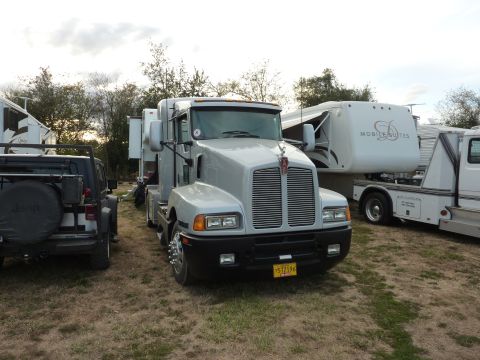 1981 Kenworth W900A - A silver semi-truck is parked outdoors, with other vehicles and RVs visible in the background.