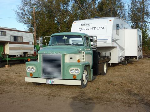 1981 Kenworth W900A - A vintage Dodge truck is shown towing a modern fifth-wheel RV, with another trailer visible in the background.