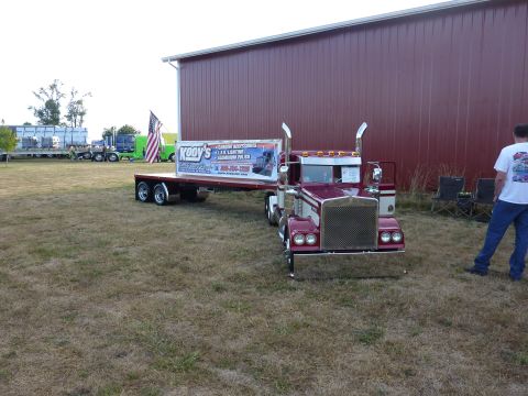 1981 Kenworth W900A - A miniature semi-truck and trailer, a prominent 'Kooy's' advertisement on the trailer, is parked on a grassy field.