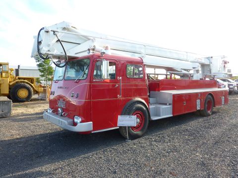 1981 Kenworth W900A - A vintage red fire truck with a large white ladder is displayed outdoors on a gravel lot.