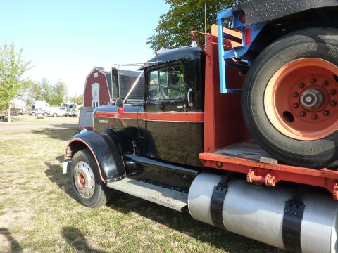 1981 Kenworth W900A - A classic Kenworth truck is parked outdoors on a sunny day, with a red barn in the background.