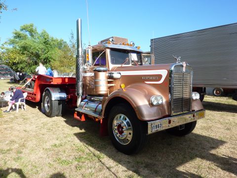1981 Kenworth W900A - A vintage Kenworth truck, identified by its '1962' license plate, is parked outdoors next to a trailer.