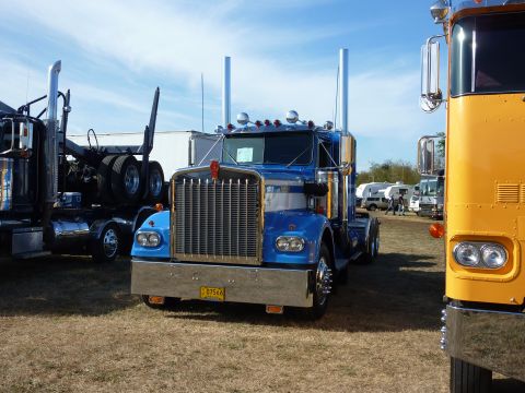 1981 Kenworth W900A - A blue 1981 Kenworth W900A semi-truck is parked outdoors with other vehicles.