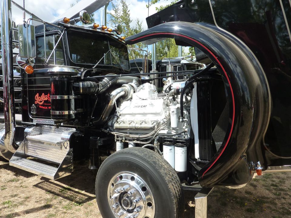 truck engine bay with CAT engine visible, hood open, chrome details