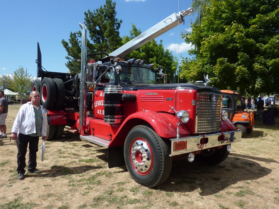 red tow truck with a man standing next to it, license plate says 1955