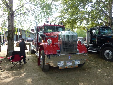 1981 Kenworth W900A - A classic red semi-truck is displayed outdoors, with another truck visible to its right.