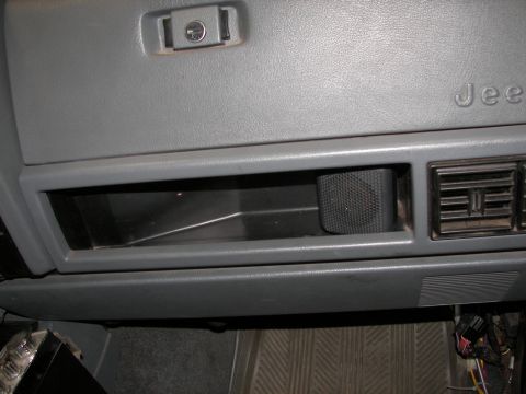 1988 Ford Bronco - Close-up of a vehicle's interior dashboard, showing the glove compartment, a speaker, and air conditioning vents. The word 'Jeep' is emboss…