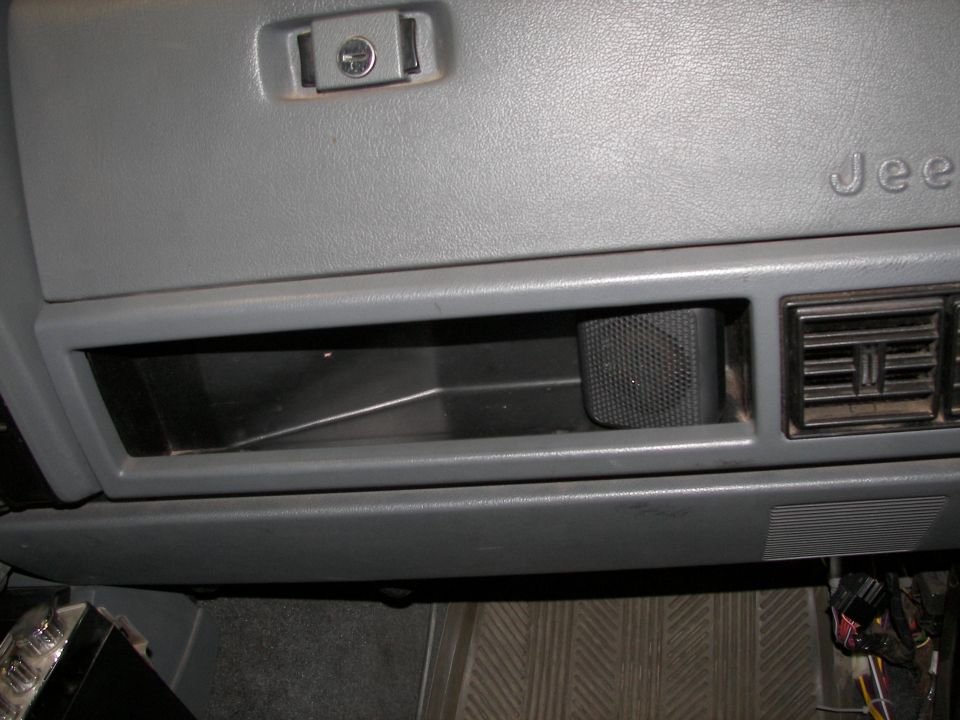 Interior dashboard with glove box, speaker, and air vents. Text 'Jeep' visible