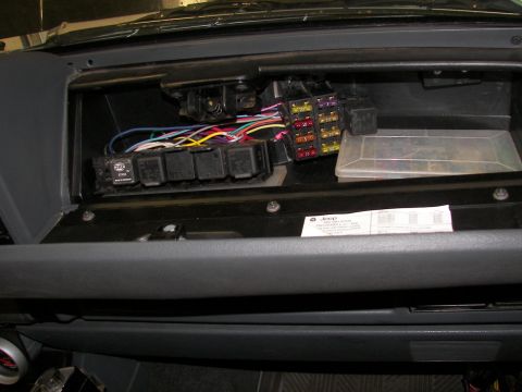1988 Ford Bronco - Interior view of a vehicle's fuse box and wiring harness, with a spare fuse container.