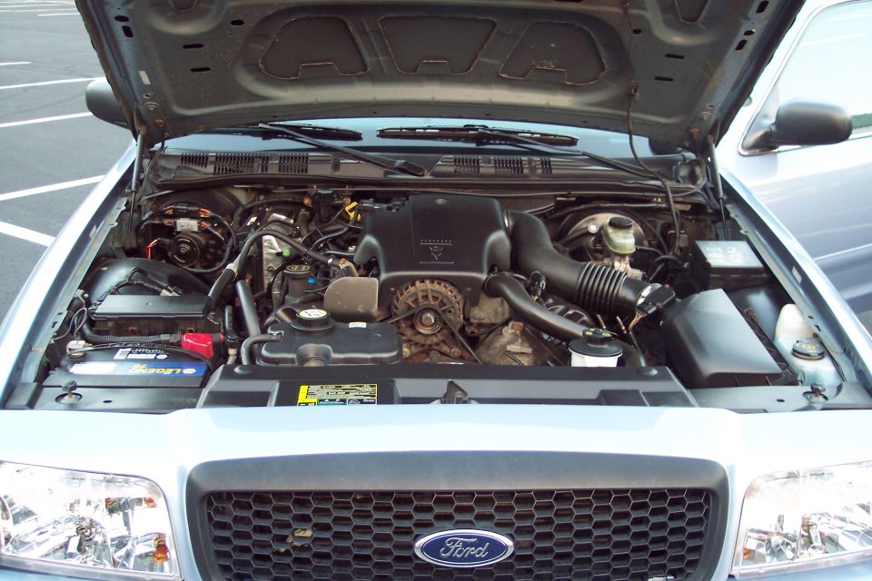 Light blue 2001 Ford Crown Victoria engine bay with hood open, showing the V8 engine and battery