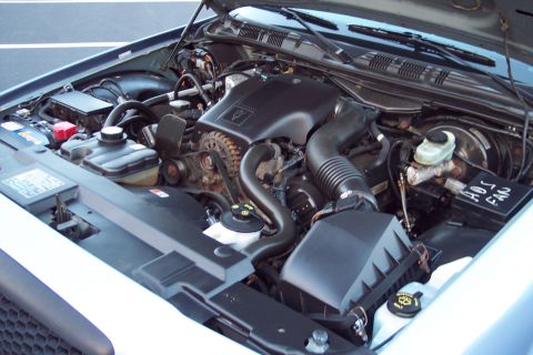 2001 Ford Crown Victoria - The engine bay of a 2001 Ford Crown Victoria is displayed, revealing the V8 engine, air intake system, and various fluid reservoirs.