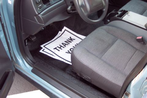 2001 Ford Crown Victoria - The interior of a 2001 Ford Crown Victoria is visible, including the driver's seat and floor mats.