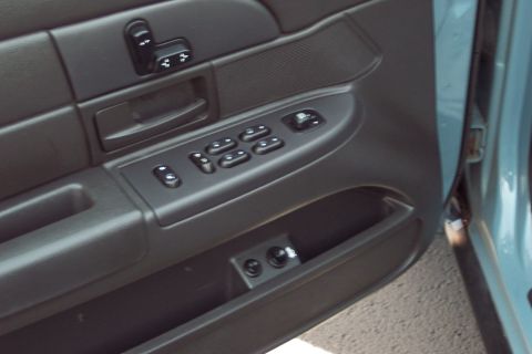 2001 Ford Crown Victoria - Close-up of a car's interior door panel, showing the window and lock controls.