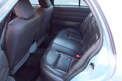 2001 Ford Crown Victoria - The interior of a light blue 2001 Ford Crown Victoria shows the rear bench seat and door panel.