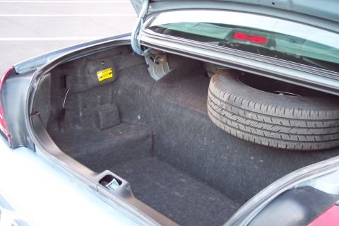 2001 Ford Crown Victoria - The trunk of a 2001 Ford Crown Victoria contains a spare tire and carpeted lining.