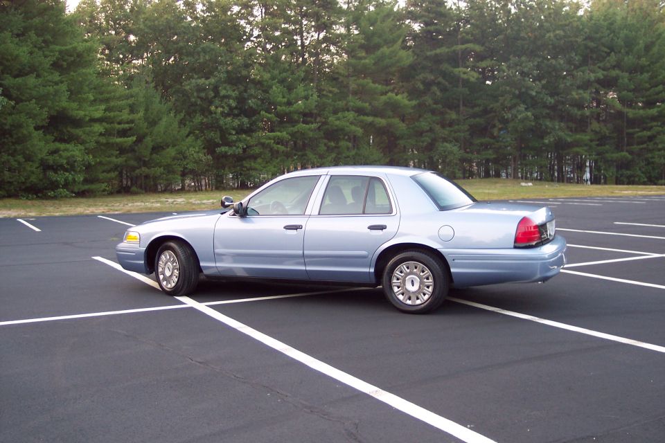 Light blue 2001 Ford Crown Victoria sedan parked in a lot, side view