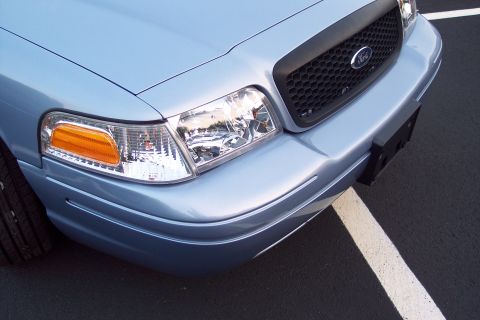 2001 Ford Crown Victoria - Front view of a light blue 2001 Ford Crown Victoria, showing the grille, headlights, and bumper.