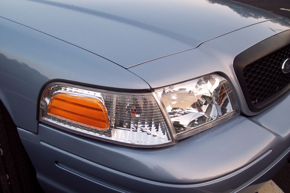 Close-up of a 2001 Ford Crown Victoria's front corner, showing the headlight and grille