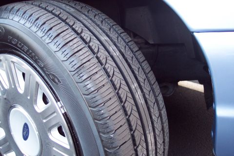 2001 Ford Crown Victoria - The front wheel and tire assembly of a 2001 Ford Crown Victoria.