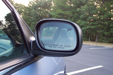 2001 Ford Crown Victoria - Reflection in the side mirror shows the interior of the car and the surrounding trees.