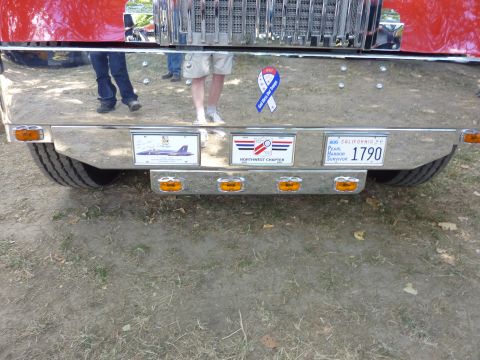 1981 Kenworth W900A - The rear of a large truck shows a license plate and several commemorative stickers.