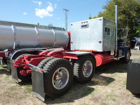1981 Kenworth W900A - A 1981 Kenworth W900A truck tractor is shown from the rear quarter, attached to a large silver tank trailer.
