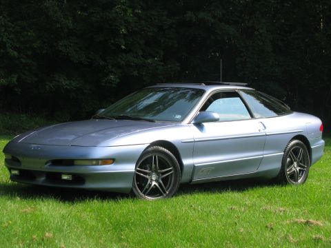 1994 Ford Probe - A blue 1994 Ford Probe GT is shown from a three-quarter front view, parked outdoors on a grassy lawn.