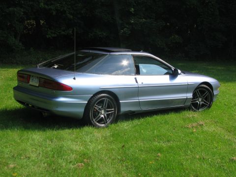1994 Ford Probe - A light blue 1994 Ford Probe is parked on a grassy lawn with trees in the background.