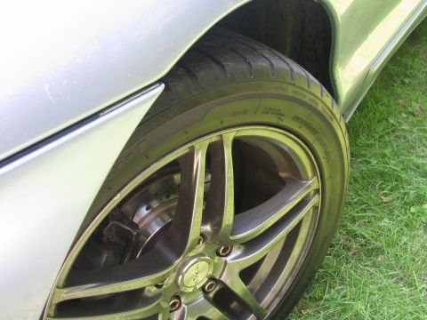 1994 Ford Probe - A close-up view of a car's wheel and fender, showing aftermarket rims and a portion of the tire.