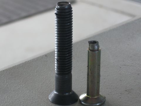 1991 Ford Bronco - A comparison of a full bolt next to a broken bolt, likely for a vehicle repair.