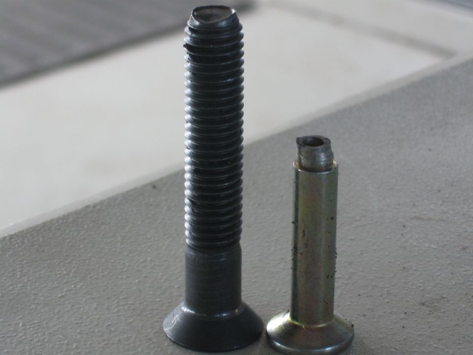 two bolts side-by-side, one is intact and threaded, the other is shorter and broken off at the top