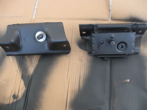 1991 Ford Bronco - Two black motor mounts are shown against a cardboard background.