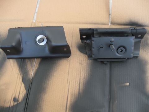 1991 Ford Bronco - Two black motor mounts, one on the left and one on the right, are shown against a cardboard background.